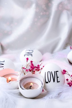 Paskalya bayramı. Kendiniz yapın. Paskalya Yumurtası Kompozisyonu. Paskalya mesajı, kalemle çizilmiş kelimeler. Masadaki kabukların yüksek açılı görüntüsü. Sevgi. Yumurta kabuğunda mum. Mum ışığı Pastel renkleri.