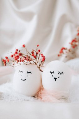 Paskalya bayramı kendin yap. Asgari paskalya konsepti. Renkli gülen yüzlü Paskalya yumurtaları ve pastel arka planda kuş tüyü. Evlenmek. Sevgililer Günü Düğün Yumurtaları. Komik yüzlü, el yapımı yumurtalı Paskalya tatili kavramı