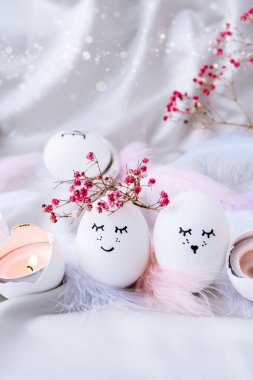 Paskalya bayramı kendin yap. Asgari paskalya konsepti. Renkli gülen yüzlü Paskalya yumurtaları ve pastel arka planda kuş tüyü. Evlenmek. Sevgililer Günü Düğün Yumurtaları. Komik yüzlü, el yapımı yumurtalı Paskalya tatili kavramı