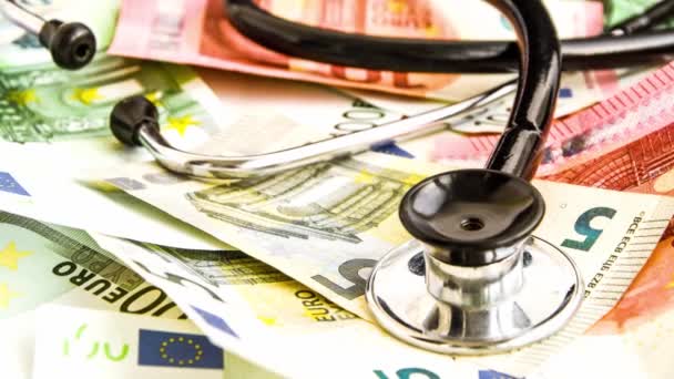 Stetoskop ve euro banknotları, Tıbbi Maliyet kavramı - Avro kağıt para bankasında steteskop 4k Zoom — Stok video