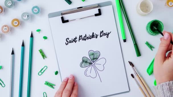 Tangan wanita melukis kartu ucapan St Patricks hari. Ide hadiah, kerajinan dekorasi. DIY. Lakukan sendiri. Clovers, kuas dan cat. — Stok Video