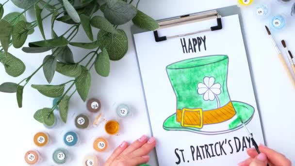 Tangan wanita melukis kartu ucapan St Patricks hari. Ide hadiah, kerajinan dekorasi. DIY. Lakukan sendiri. Clovers, kuas dan cat. — Stok Video