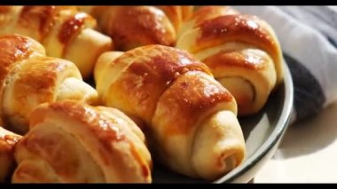 Mutfak havlusunda dönen tatlı gri bir tabakta ev yapımı lezzetli kruvasanlar. Lezzetli ev yapımı kruvasan keki