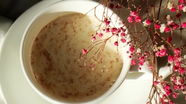 Taza blanca de leche y chocolate. Sensaciones estéticas matutinas. El desayuno. Flores de gypsophila — Vídeos de Stock