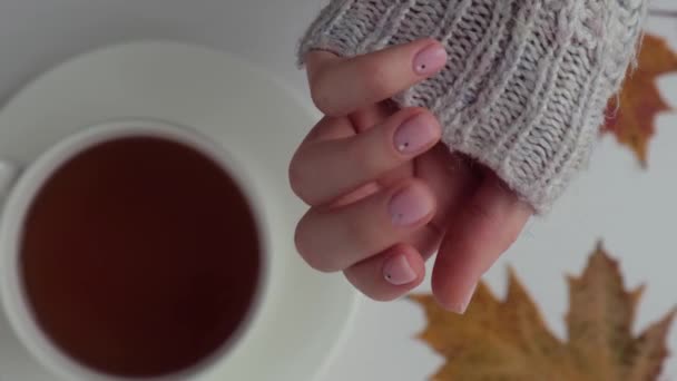 Femme montrant les mains avec une belle manucure nue tenant des feuilles d'automne. Manucure féminine, aspect naturel. Les ongles comptent. L'auto-soin. Tasse à thé — Video