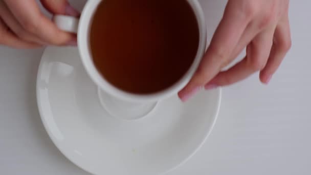 Жінка показує руки з прекрасним оголеним манікюром з чашкою чаю. Жіночий манікюр, природний вигляд. Небайдужі нігті. Самодогляд. — стокове відео
