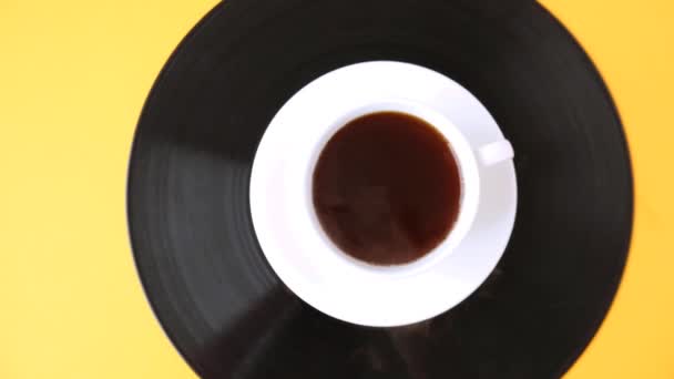 Een kop zwarte koffie staat op vinyl plaat. Dampende kop koffie. — Stockvideo