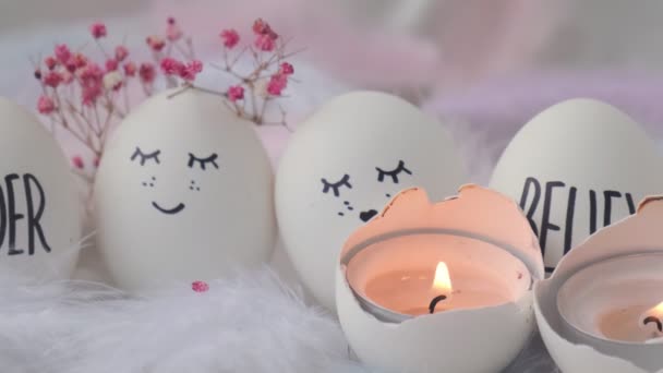 Filmagem de acender uma vela em ovos de Páscoa Composição. Ovos de Páscoa com rostos sorridentes pintados. Aconchegante decoração de interiores casa, queimando velas. Casamento dois ovos. Casado — Vídeo de Stock