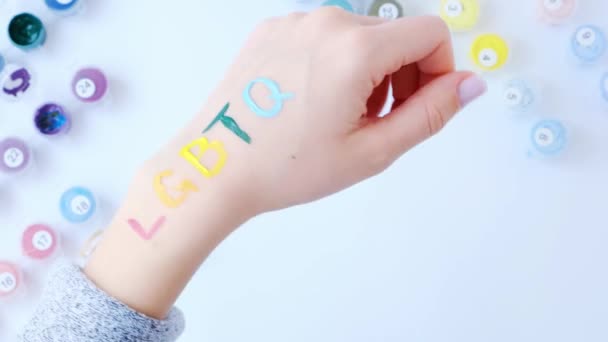 Regenboog LGBTQ vlag geschilderd bij de hand. Steun voor de Igbt gemeenschap. Eer van trotse maand. Mensen verbinden, handen aanraken. — Stockvideo