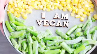 Kadın eli tut. Ben VEGAN 'ın tabağındayım. Vejetaryenlik, vejetaryen sağlıklı yaşam tarzı. Sağlıklı beslenme vegan, yeşil fasulye sarı mısır