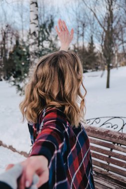 Kış parkında pançolu, kıvırcık, sarışın, güzel bir kadın. Soğuk hava. Tatiller, sezon ve eğlence konsepti. Noel, Yeni Yıl.