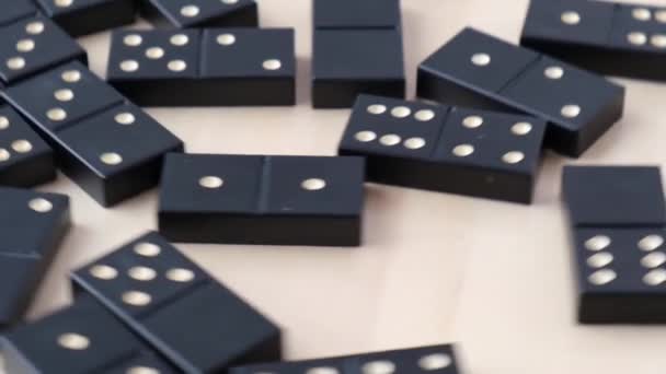 Domino dadi nero con puntini bianchi che ruotano intorno su sfondo di legno. Concentrazione selettiva. Al rallentatore. Giochi da tavolo per compagnia di amici. Resta a casa. — Video Stock