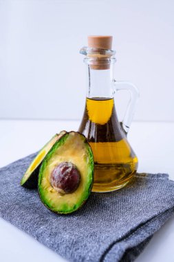 Bir sürahi doğal yağ ve taze olgun hass avokado. Mutfakta yemek hazırlıyorum. Malzemeler. Sağlıklı gıda kavramı. Sağlıklı beslenme. Keto diyeti