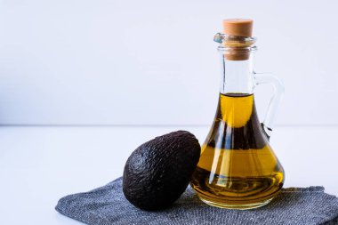 Bir sürahi doğal yağ ve taze olgun hass avokado. Mutfakta yemek hazırlıyorum. Malzemeler. Sağlıklı gıda kavramı. Sağlıklı beslenme. Keto diyeti