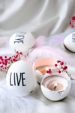 Paskalya bayramı. Kendiniz yapın. Paskalya Yumurtası Kompozisyonu. Paskalya mesajı, kalemle çizilmiş kelimeler. Masadaki kabukların yüksek açılı görüntüsü. Yaşa. Yumurta kabuğunda mum. Mum ışığı Pastel renkleri.