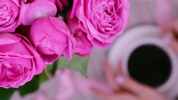 Tazza di caffè e rose rosa. Concetto di vacanza, mazzo di rose per un compleanno, mazzo di fiori alla colazione del mattino. Donna beve cappuccino — Video Stock