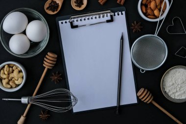 Siyah arka planda pişirme malzemeleri. Üst Manzara. Boş pano kopyalama alanı. Ev yapımı: kurabiye, ekmek, pasta. Tarçın çubukları, ceviz, baharatlı yumurta unu.