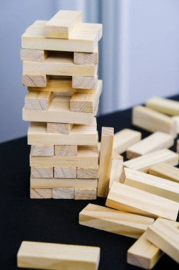 Tahta bloklardan yapılmış. Arka planda Hand olan tahta bloklar oyunu istifliyor. Takım çalışmasının kavramı. Mimari modele sahip blok kulesi, yönetim ve strateji riski, büyüme işi başarı süreci