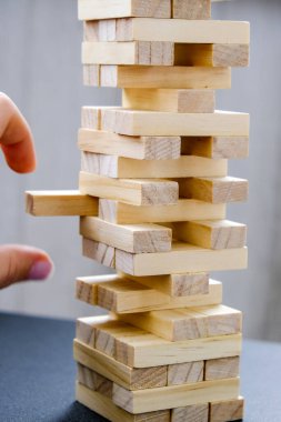 Tahta bloklardan yapılmış. Arka planda Hand olan tahta bloklar oyunu istifliyor. Takım çalışmasının kavramı. Mimari modele sahip blok kulesi, yönetim ve strateji riski, büyüme işi başarı süreci