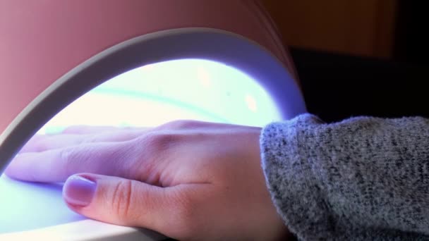 4k video led lampa Kosmetický salon návštěvník vysuší základní gel na ultrafialové lampy. Péče o nehty, péče o sebe. Udělej si manikúru sám, zatímco budeš doma. Diy — Stock video