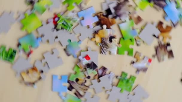 Családi szabadidő. Különös alakú egymásba fonódó és mozaikos kirakós darabok. Teljesen egymásba fonódó puzzle forgó fa asztalon — Stock videók