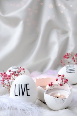 Paskalya bayramı. Kendiniz yapın. Paskalya Yumurtası Kompozisyonu. Paskalya mesajı, kalemle çizilmiş kelimeler. Masadaki kabukların yüksek açılı görüntüsü. Yaşa. Yumurta kabuğunda mum. Mum ışığı Pastel renkleri.