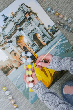 Triumphal Arch Paris 'ten kadın el boyama resmi. Yaratıcı hobi. Yeni başlayanlar için resim yapmak. Evde yalnız kalmak için boş zaman aktivitesi, anti-stres fikri. Meditasyon, rahatlama konsepti