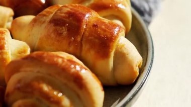 Mutfak havlusunda dönen tatlı gri bir tabakta ev yapımı lezzetli kruvasanlar. Lezzetli ev yapımı kruvasan keki