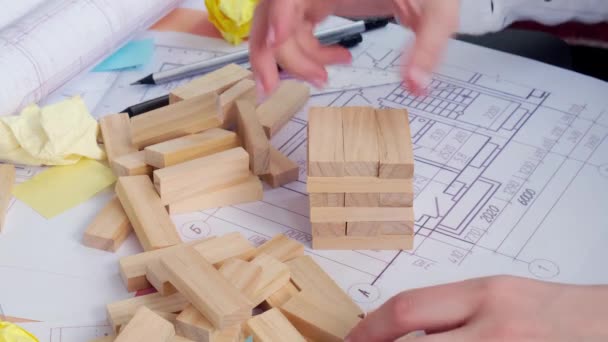 4k Arquiteto designer Interior criativo mão de trabalho jogando jogo de madeira bloco na mesa plano arquitetônico da casa, paleta de cores. Arquiteta feminina desenhando plantas no local de trabalho do escritório. — Vídeo de Stock