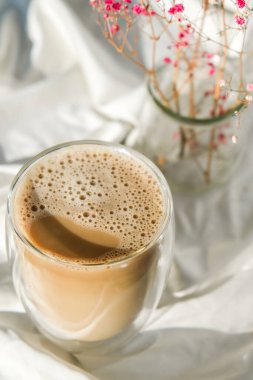 Bir fincan latte cappuccino. Sabah kahvesi estetik titreşimleri. Kahvaltıda. Pembe çingene çiçekleri.