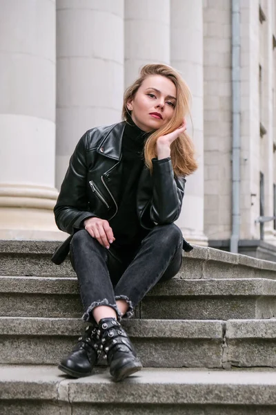 Retrato de una joven rubia con labios rojos con chaqueta de cuero en las escaleras del edificio corporativo. Empresaria profesional. Calle urbana ciudad estilo de vida —  Fotos de Stock