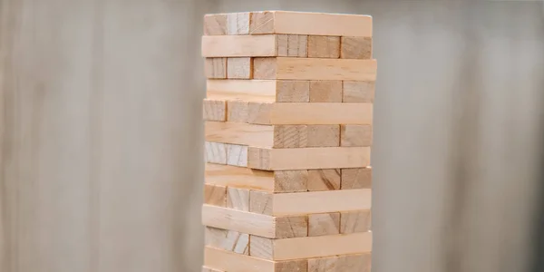 Building from wooden blocks. Wood blocks stack game with Hand on background. Conceptual of Teamwork. Block tower with architecture model, Risk of management and strategy plan, growth business success process