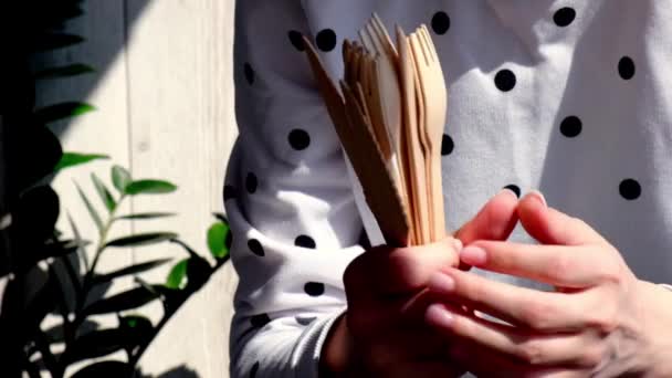 Slow motion Vrouwelijke handen die Houten vorken en papieren kopjes met borden vasthouden. Milieuvriendelijk wegwerp servies. Gebruikt in fastfood, restaurants, afhaalmaaltijden, picknicks. Geen plastic — Stockvideo