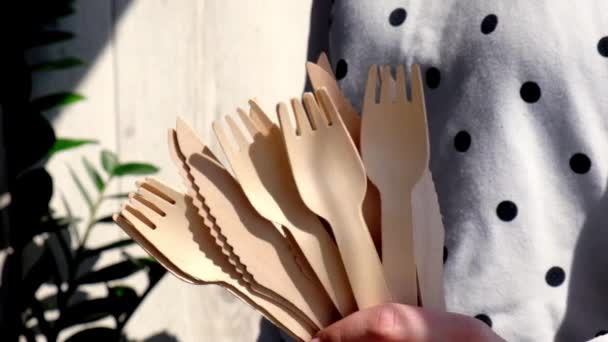 缓慢运动的女性手拿着木制叉子和装有盘子的纸杯。环保的一次性餐具。用于快餐、餐馆、外卖、野餐。没有塑料 — 图库视频影像