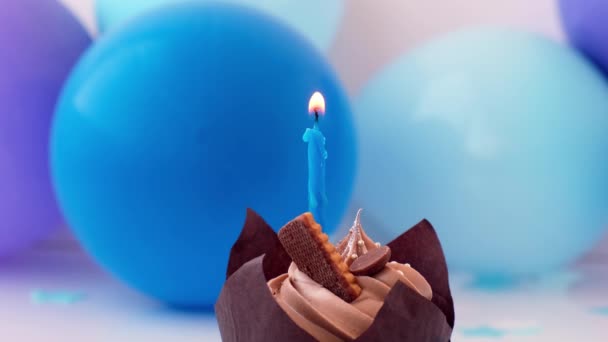 Bolo de chocolate saboroso doce com vela queimando no fundo festivo azul. Chama, soprar para fora o conceito feliz da festa de aniversário. Delicioso bolo de aniversário — Vídeo de Stock
