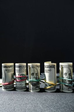 Dolar arkaplanındaki izole edilmiş dolar destesi. Kağıt banknotlar, para ruloları ve lastik bantlar. Zenginlik ve refah finansmanı iş bütçesi. Amerikan dolarlarının yığın sermayesi nakit.