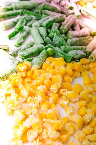 Frozen vegetables food background of yellow corn, green beans. Harvest Food preservation for winter. Veganism, vegetarian healthy eating. Selective focus