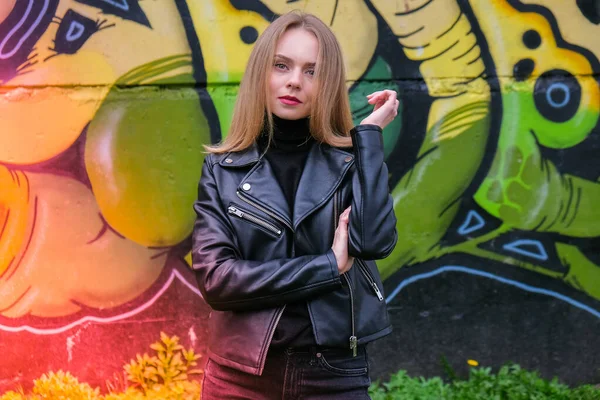 Młoda blondynka obok ściany graffiti. Sztuka uliczna i współczesny proces malowania. Styl życia ulicy. — Zdjęcie stockowe