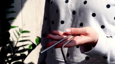 Ağır çekim Kadını Yeniden Kullanılabilir Metal Kamış 'ı tutuyor. Yeniden kullanılabilen katlanabilir pipetin üzerindeki kadın el. Eko yaşam tarzı ve sıfır atık konsepti. Plastiksiz