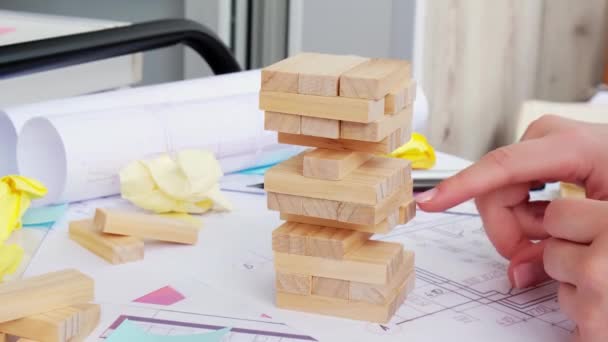 4k Architekt Designer Interior kreative Arbeitshand spielen Block Holz Spiel auf dem Schreibtisch architektonischen Plan des Hauses, Farbpalette. Architektin zeichnet Entwürfe für Büroarbeitsplätze. — Stockvideo