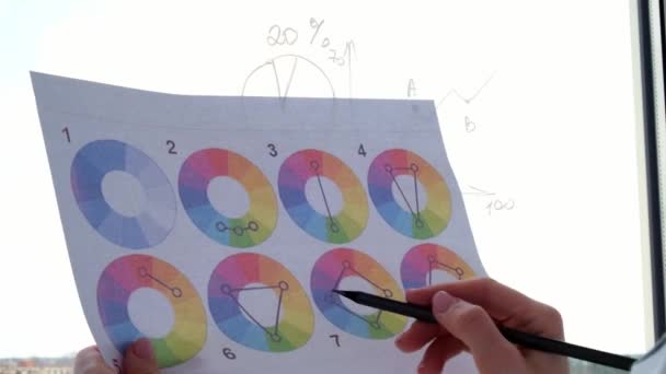 4k Innenarchitektin mit Farbpalette im Amt. Arbeitsplatzfenster. Architekt bei der Arbeit. Bunte Tortendiagramme und Diagramme — Stockvideo