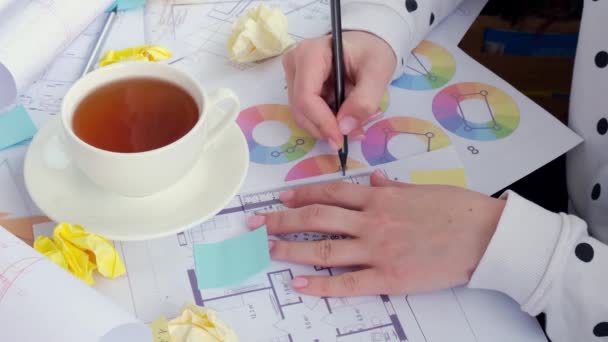 4k 아키 텍 트 디자이너 인테리어의 창의적 인 작업 손 그림 사무실에서 도면 도면을 그릴 수있습니다. 사무실 설계 도면 위에 색 팔레트가 있습니다. 여성 건축가 — 비디오