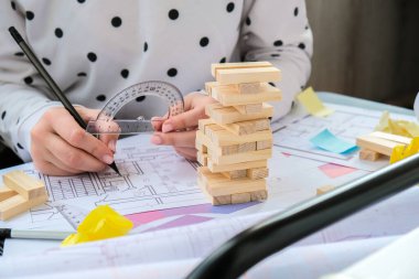 Mimar tasarımcı iç mimar yaratıcı işçi el evin masa mimarisi planı üzerine bir blok tahtası oyunu oynuyor, bir renk paleti. Kadın mimar ofis işyerinin planlarını çiziyor. Çalışma Alanı