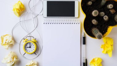 Cep telefonu kulaklığı, fotokopi alanı, çalar saati ve kaktüsü olan yaratıcı bir iş yeri. Ev kavramından çalış. Online eğitim. Üst Manzara. Düz yatıyordu.