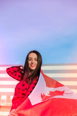 Kanada Ulusal Bayrağı 'nı tutan genç, milenyum esmer kadın. Kanada Bayrağı ya da Akçaağaç Yaprağı. Turist ya da vatanseverlik. Özgür bir ülkede göçmen. Bağımsızlık Günü 1 Temmuz