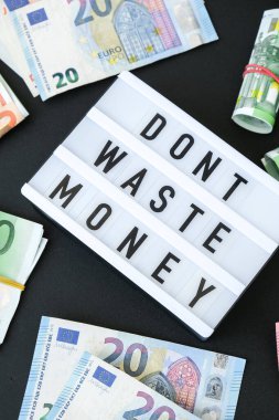Üzerinde Avro banknotları etrafında siyah harflerle DONT Atık Para yazan ışıklı tahta. Para, iş, finans, yatırım, tasarruf. Nakit para. Zenginlik ve refah finansmanı iş bütçesi. Pasif gelir