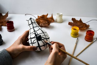 Kadınlar Cadılar Bayramı 'nda balkabağına örümcek boyar. Sonbahar yaprakları. Çocuklar el işi yapar. Kendiniz yapın. Sonbahar partisi dekorasyonları