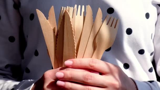 缓慢运动的女性手拿着木制叉子和装有盘子的纸杯。环保的一次性餐具。用于快餐、餐馆、外卖、野餐。没有塑料 — 图库视频影像