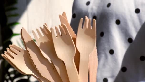 Zeitlupe Weibliche Hände halten Holzgabeln und Pappbecher mit Tellern in der Hand. Umweltfreundliches Einweggeschirr. Wird in Fast Food, Restaurants, Imbissen, Picknicks verwendet. Kein Plastik — Stockvideo