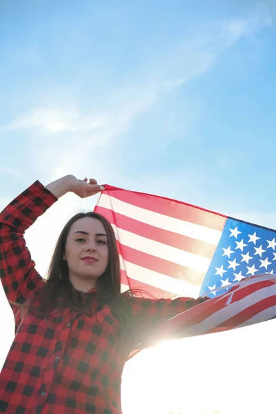 Joven morena milenaria sosteniendo La Bandera Nacional de USA. Bandera Americana. Viajero turístico o patriotismo. Inmigrante en el país libre. 4 de julio Día de la Independencia. Caucásica —  Fotos de Stock